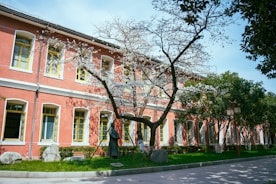 a tree in front of a red building