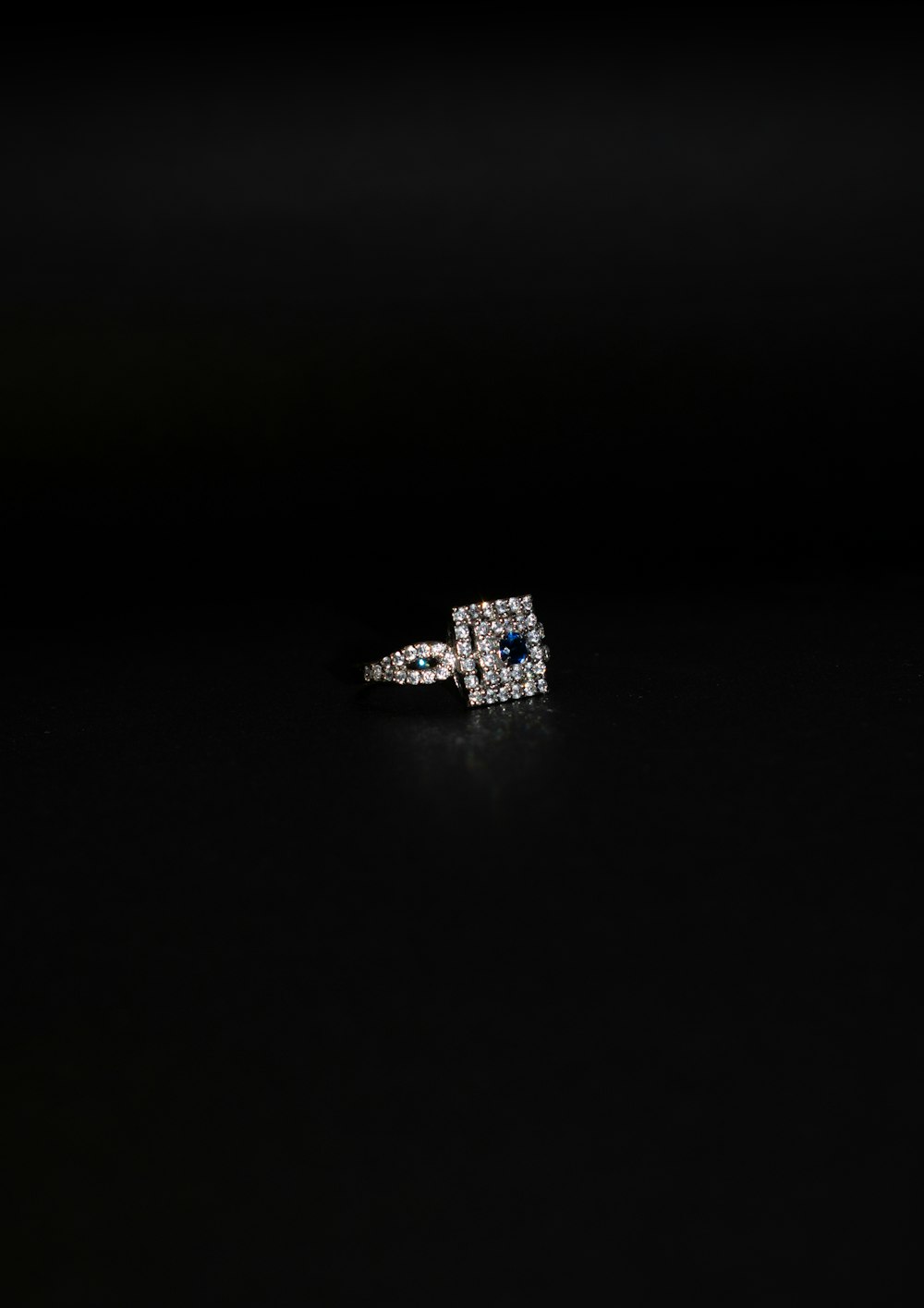 a diamond and sapphire ring on a black background