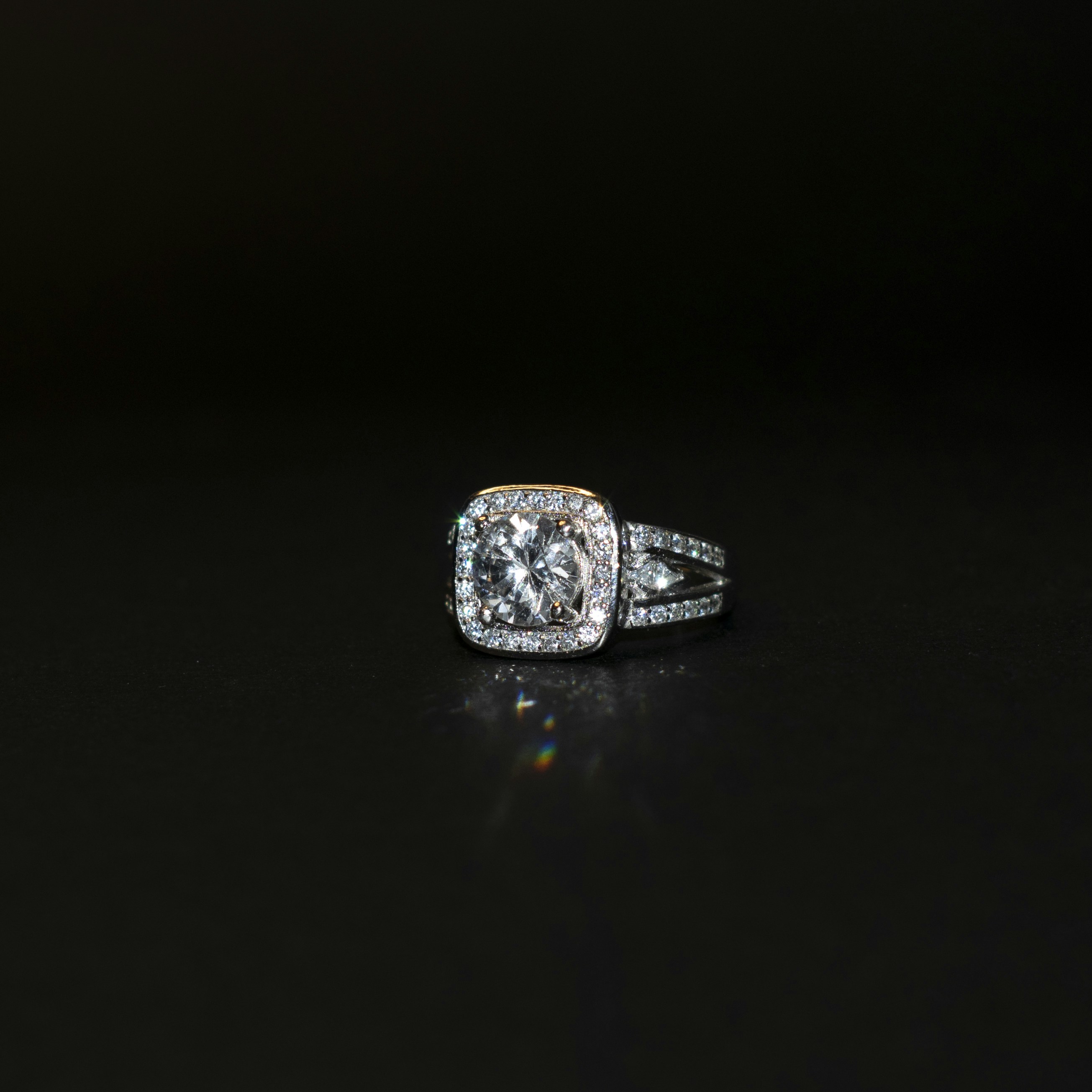 a diamond ring on a black surface