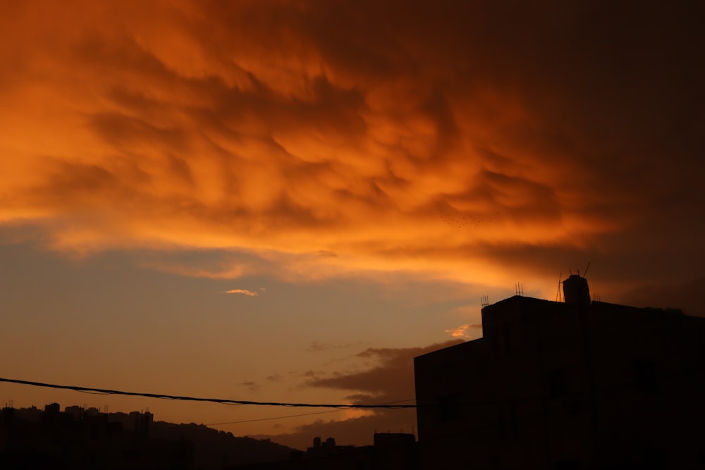 a sunset view of a building with clouds in the background