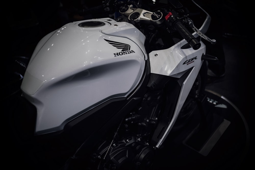 a close up of a white motorcycle in a dark room