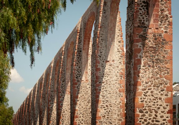 A row of stone pillars next to a tree — Querétaro, Mexico