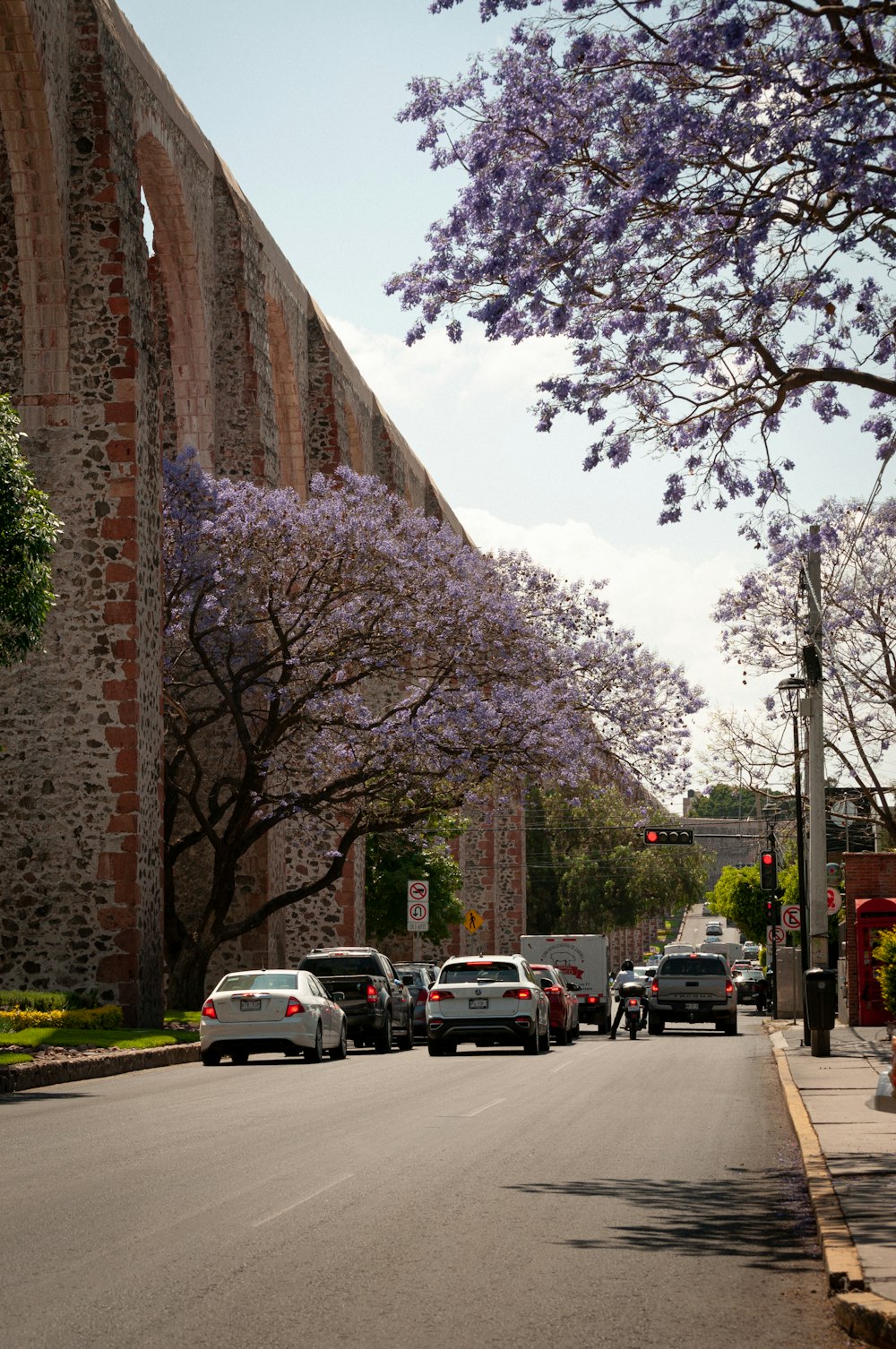 a street lined with parked cars next to a tall brick building