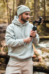 An influencer filming a product review in a forest setting.