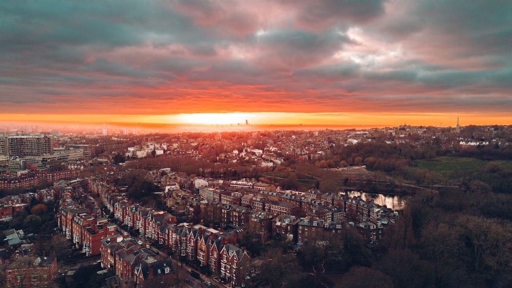 the sun is setting over a city with tall buildings