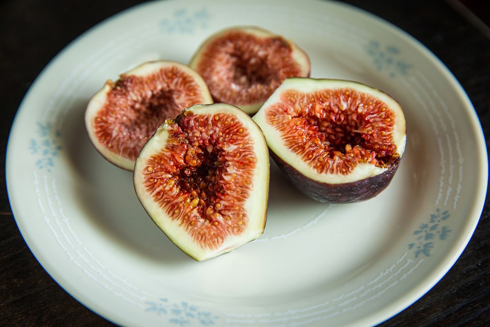 a white plate topped with sliced figs on top of a table