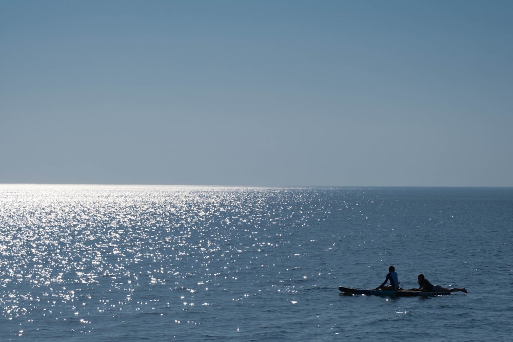 two people in a boat in the middle of the ocean