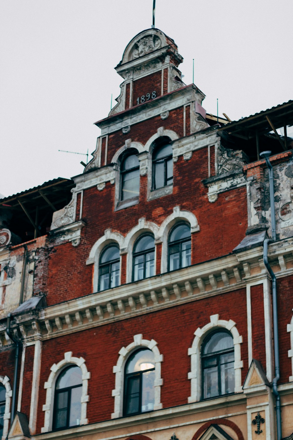 ein großes rotes Backsteingebäude mit einem Uhrturm