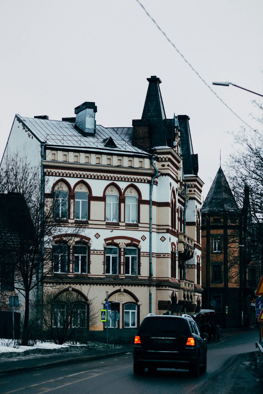 a car driving down a street next to a tall building