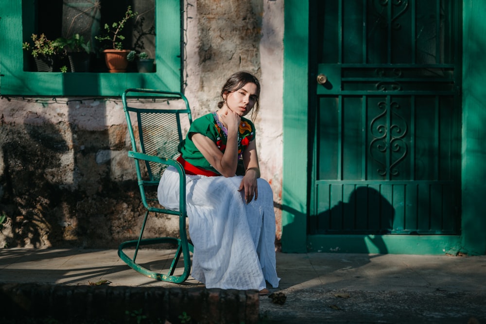 a woman sitting on a chair outside of a building