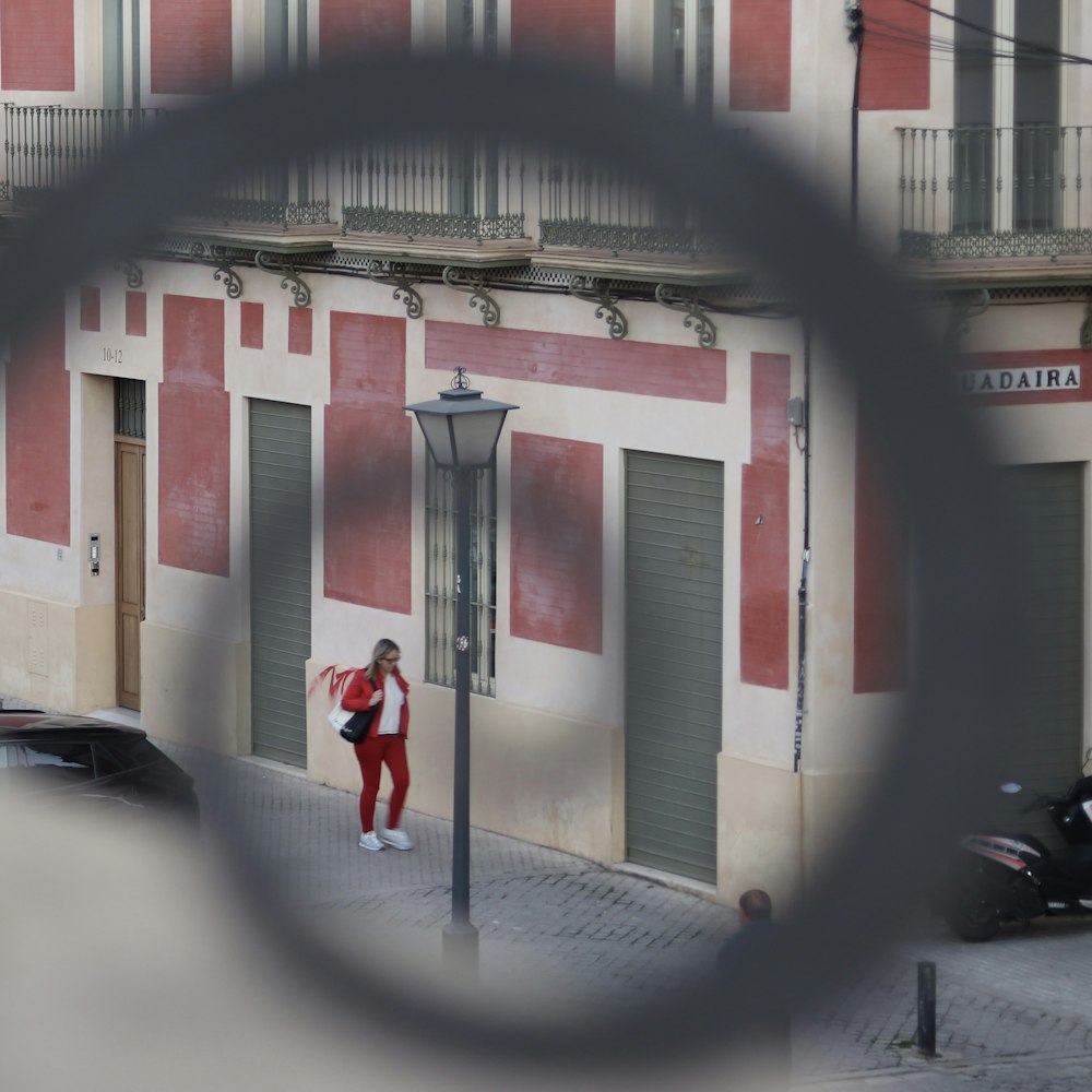 a woman standing on a street corner in front of a building