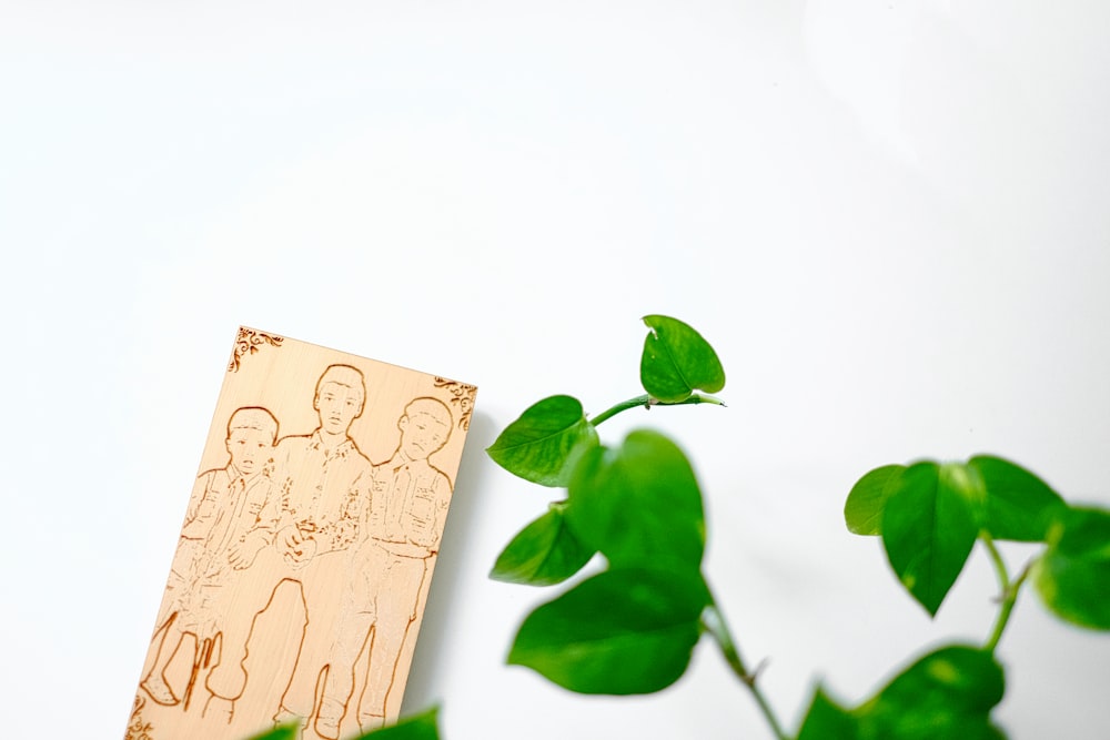 uma imagem de um homem e uma criança em uma placa ao lado de uma planta