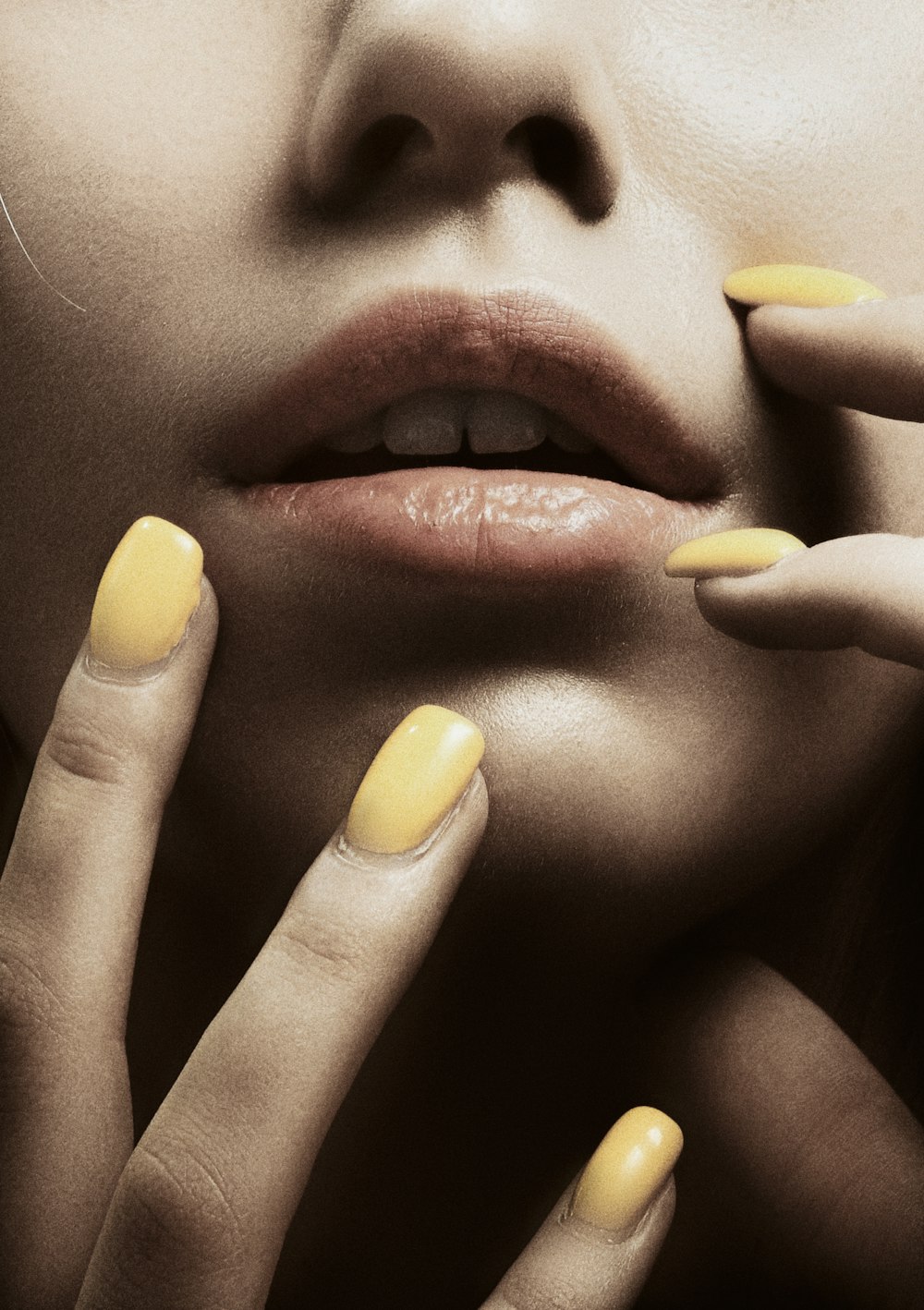 a woman with yellow nail polish on her nails