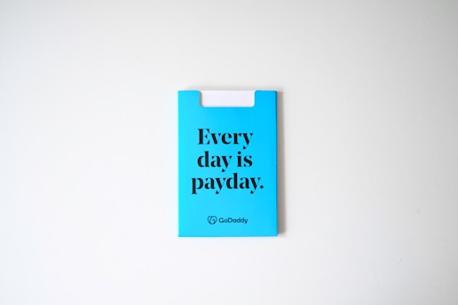 A blue card with the phrase 'Every day is payday.' printed in bold black letters. The card also has a GoDaddy logo at the bottom.