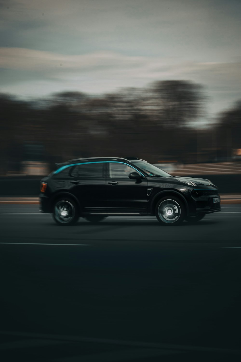 a black suv driving down a street at night