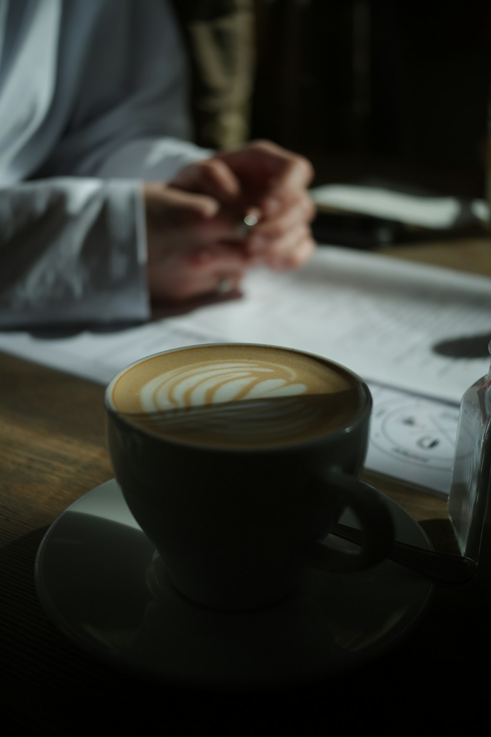 a cup of coffee sitting on top of a wooden table