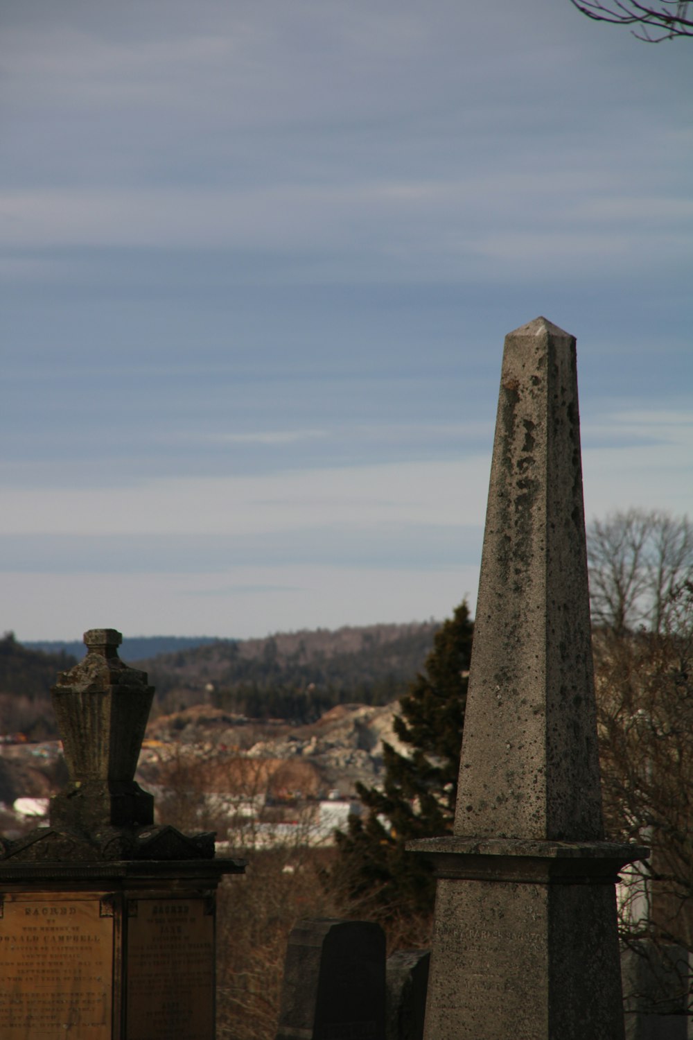 a cemetery with a tall obelisk in the background