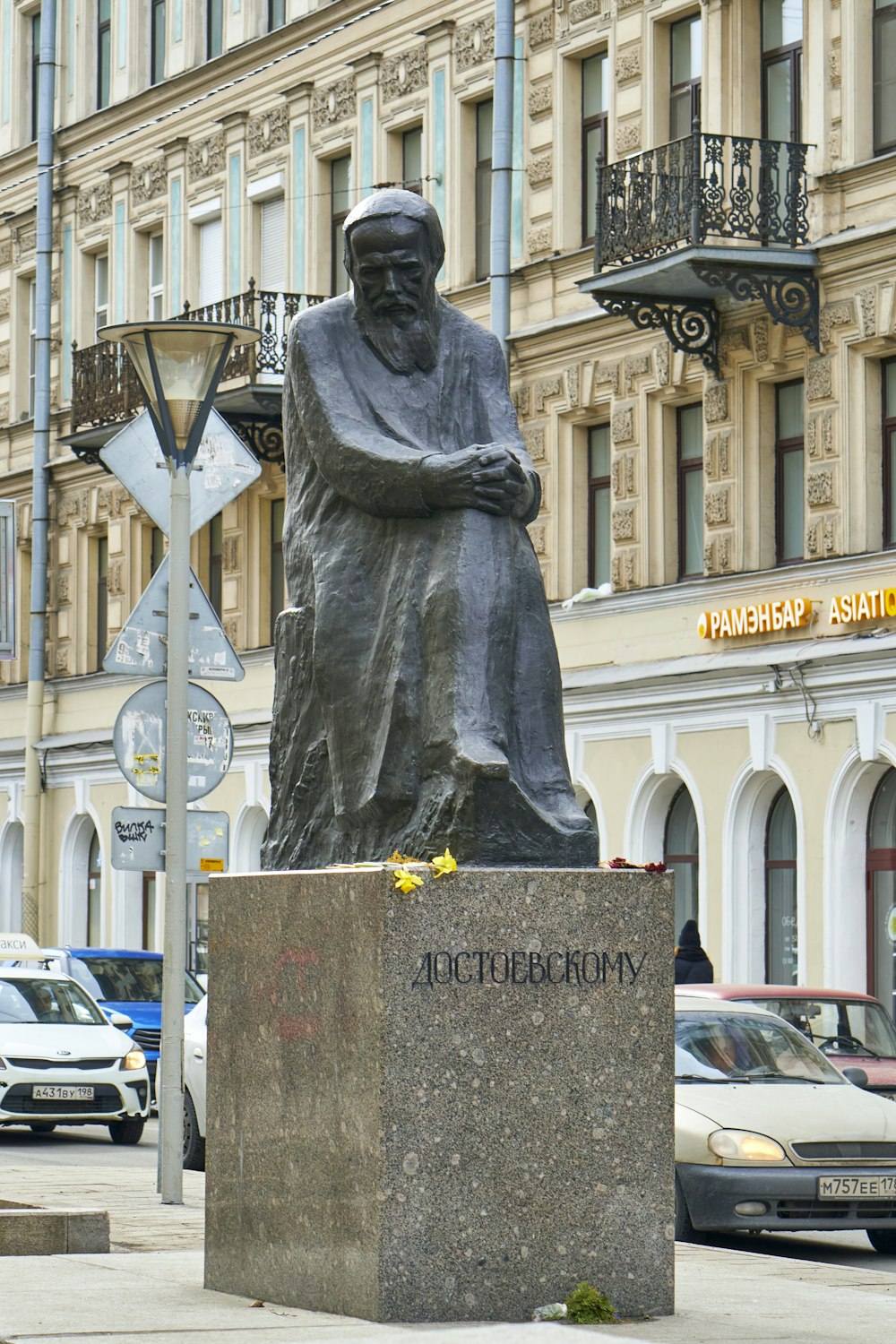 a statue of a man holding a cross in front of a building