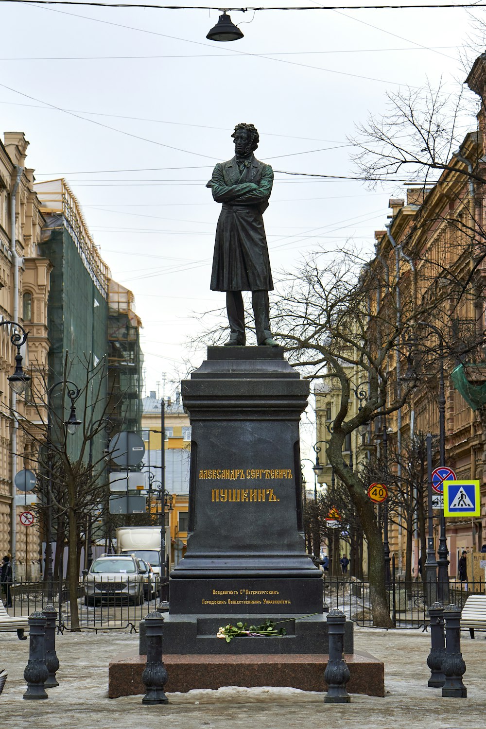 Una statua di un uomo in piedi sulla cima di un piedistallo