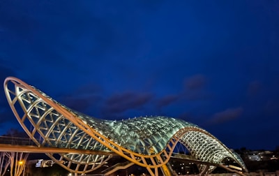 A sleek steel bridge structure illuminated at dusk, showcasing intricate engineering details.