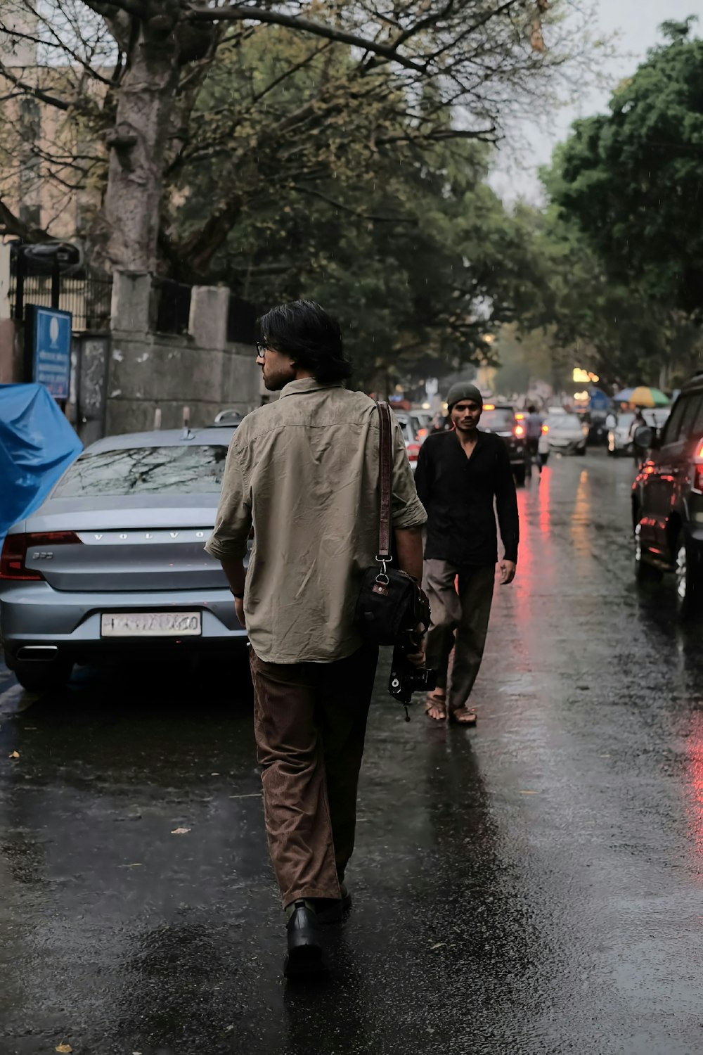 Un hombre caminando por una calle sosteniendo un paraguas