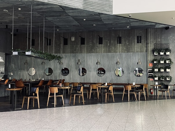 a restaurant with tables and chairs and a wall of mirrors