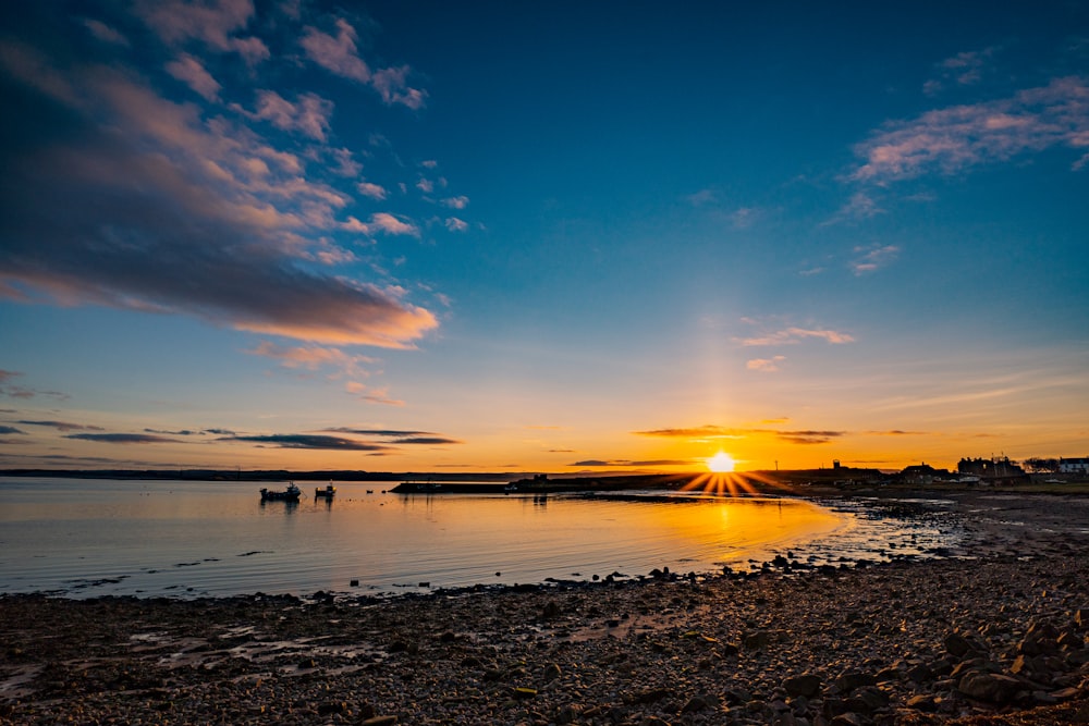 the sun is setting over a body of water