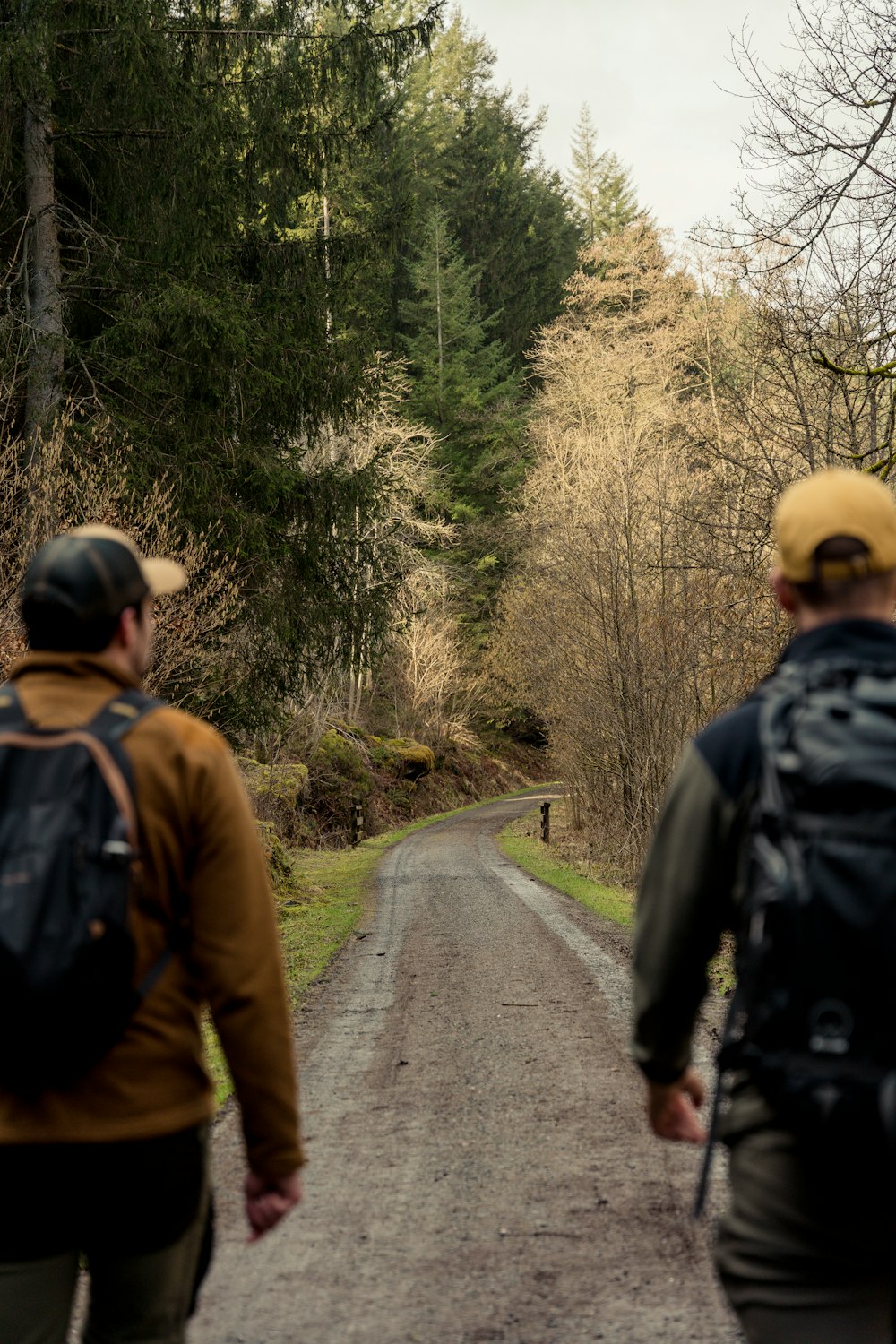 a couple of men walking down a dirt road