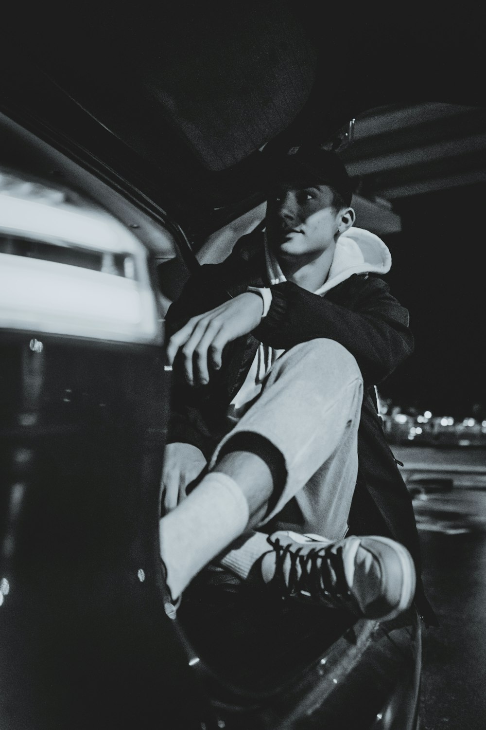 a man sitting on the hood of a car