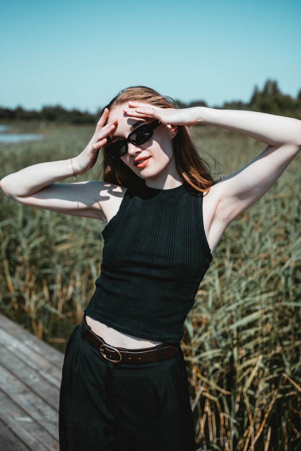 a woman in a black top is standing in a field