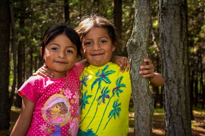 Photo of children wearing Mikkie™ t-shirts and hoodies in a lush forest setting