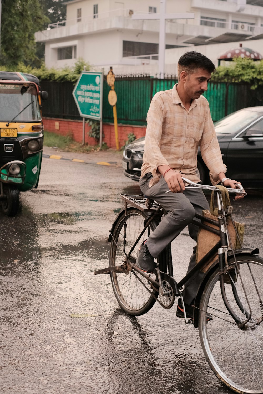 a man riding a bike down a rain soaked street