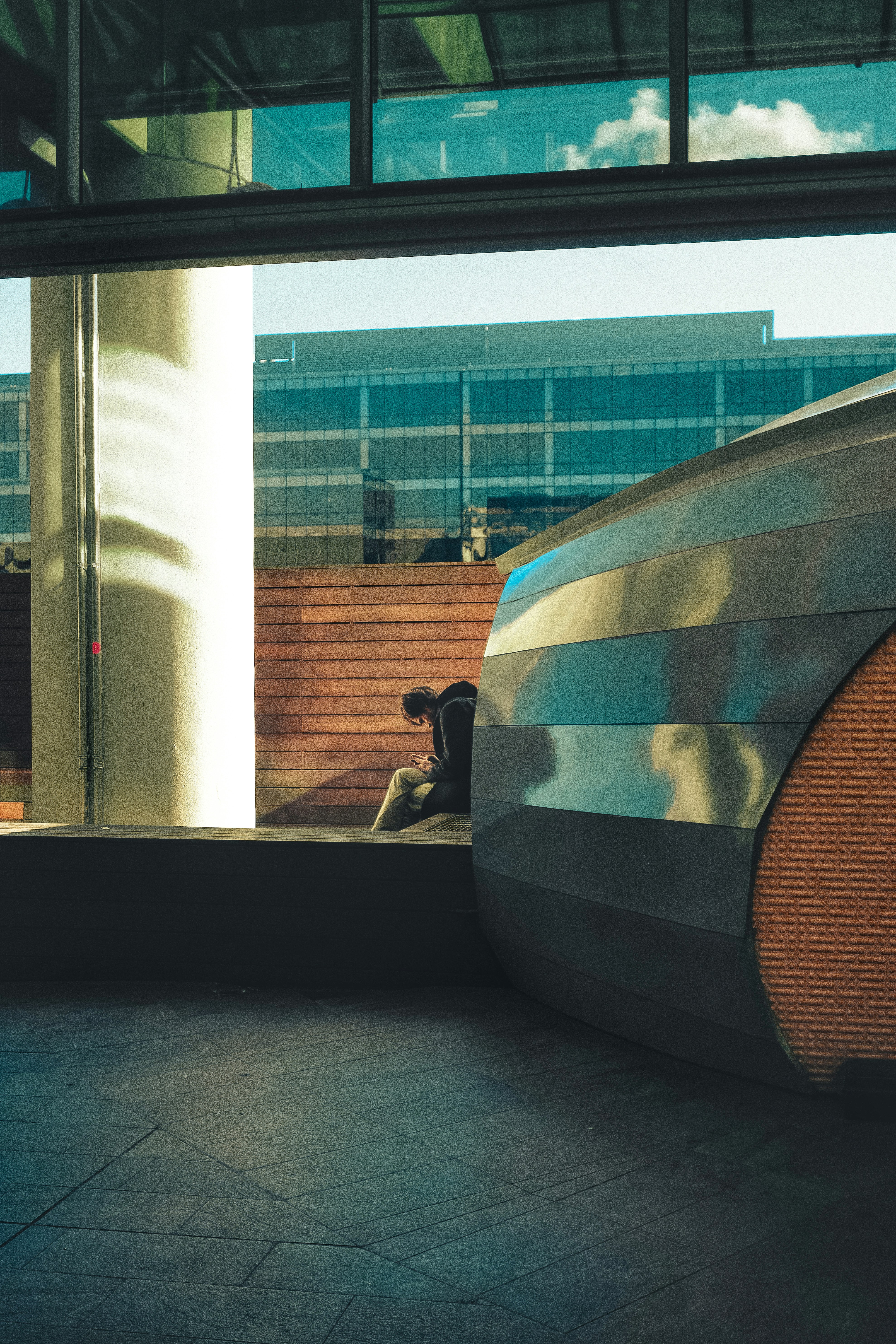 a person sitting on a bench in front of a building