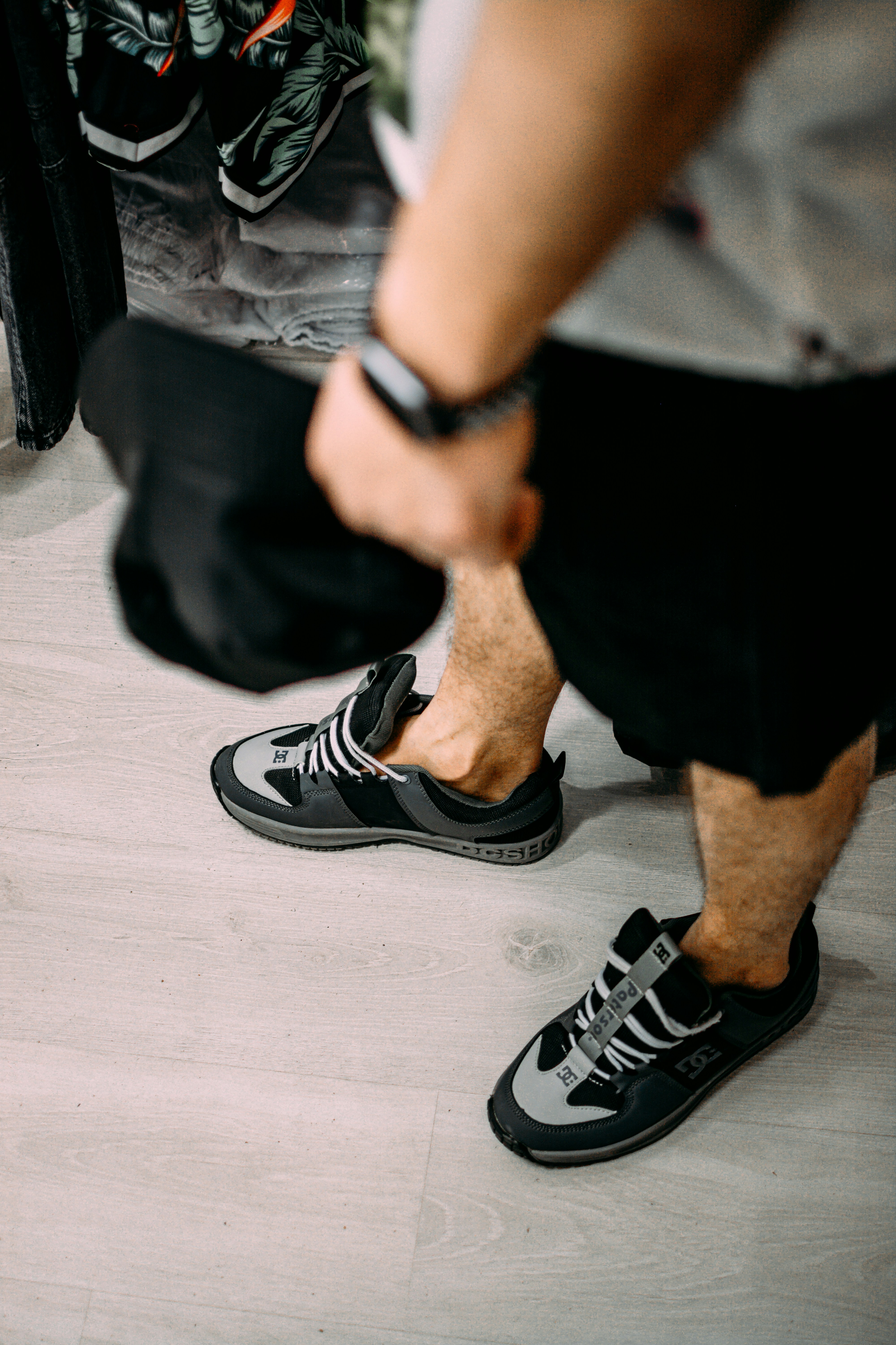 a man in black and white shoes sitting on the floor