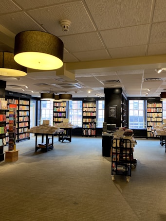 a library filled with lots of books next to a window