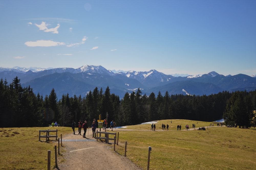 a group of people walking down a dirt road