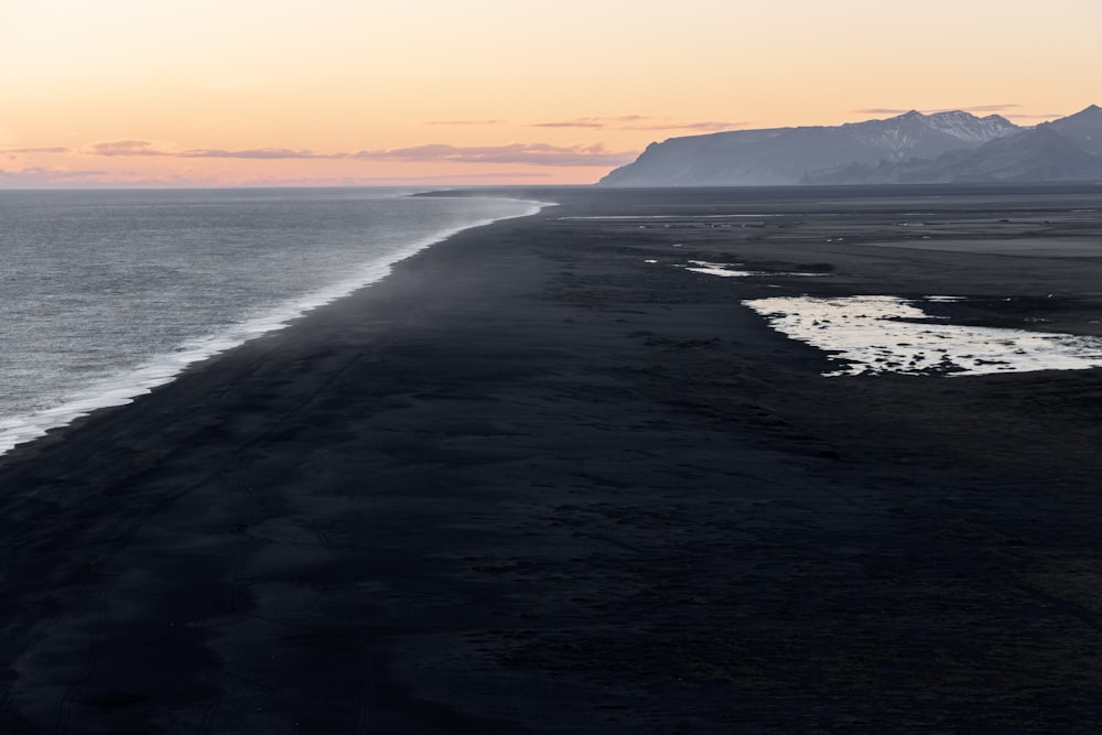 a long stretch of beach next to a body of water