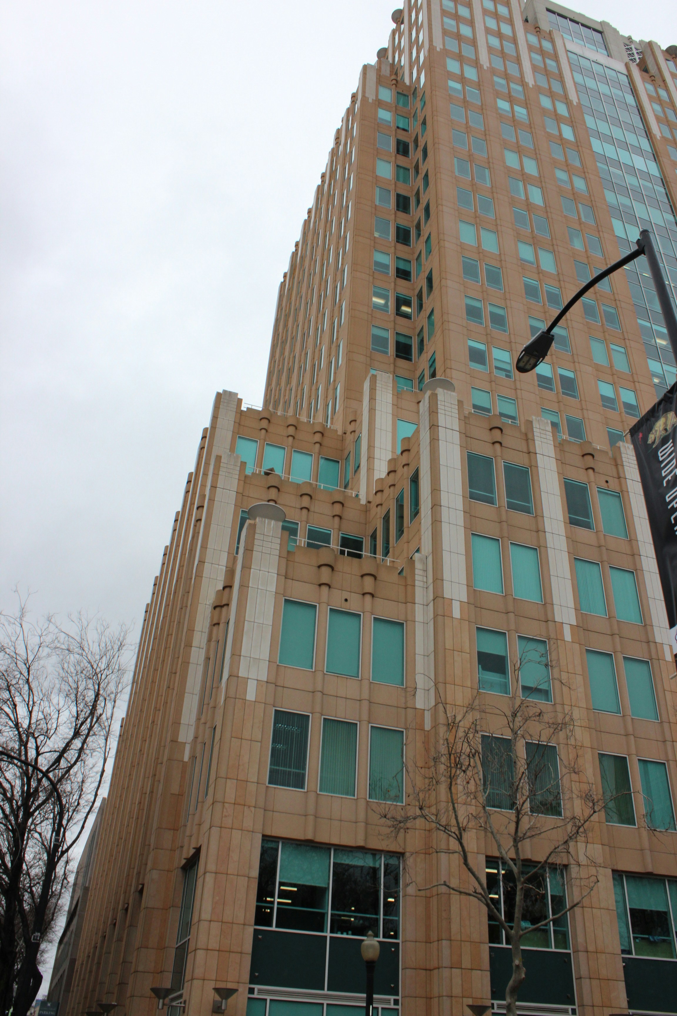 Un edificio alto con un lampione di fronte ad esso
