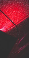 a red car with rain drops on it