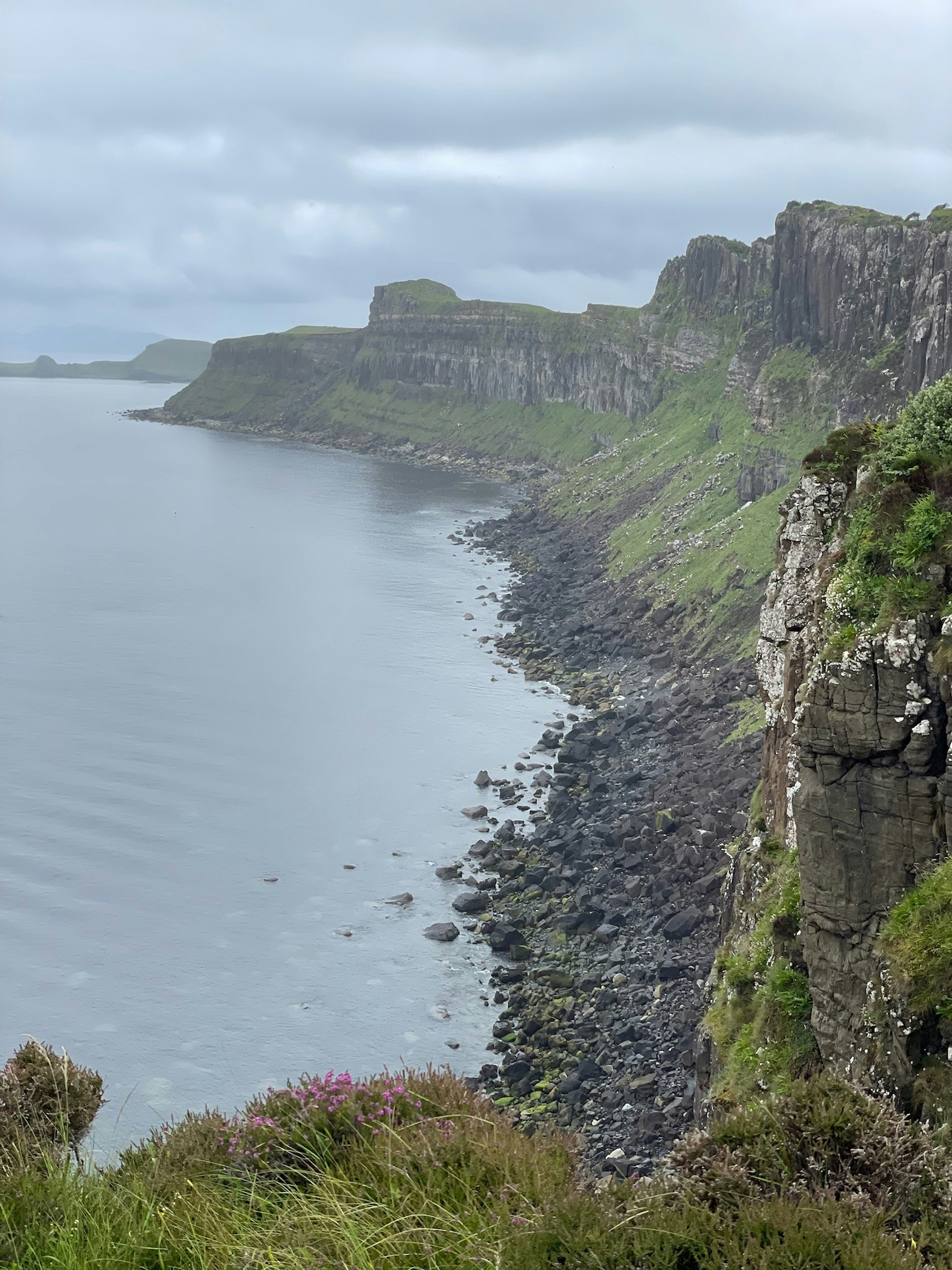 Wild Breton Atlantic coastline with dramatic cliffs, grey-blue ocean, overcast dramatic sky