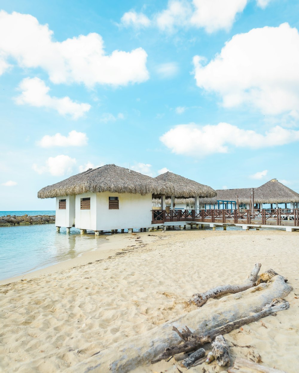 a beach with a thatched roof next to the ocean