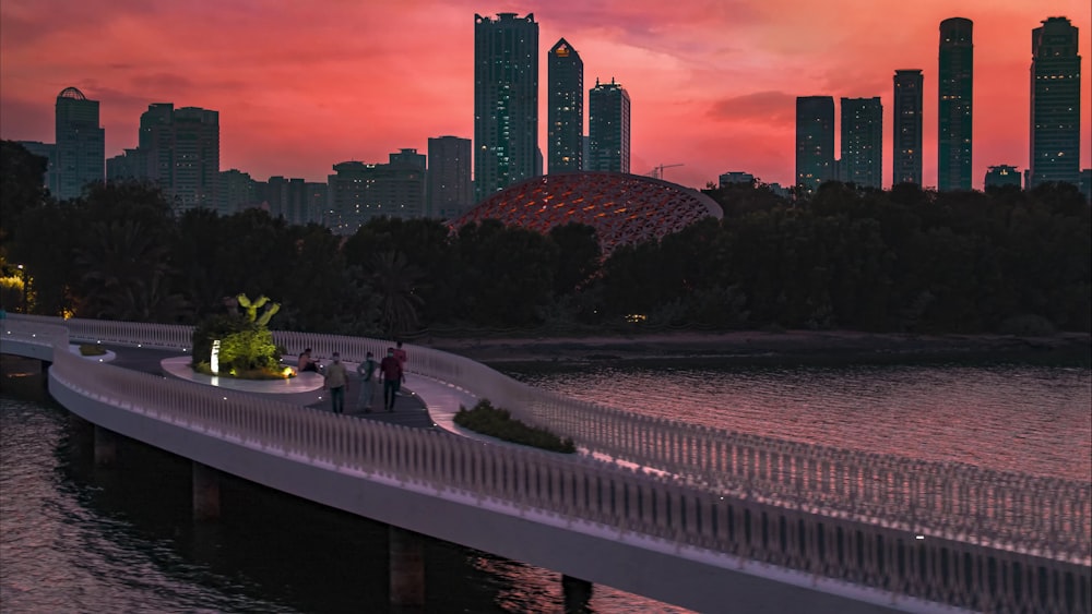 a bridge with people walking across it and a city in the background