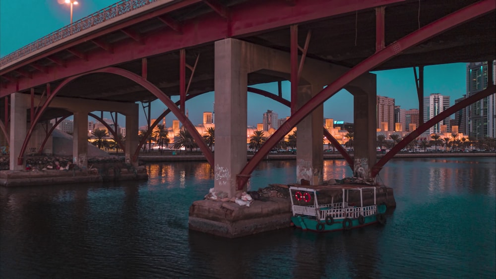 a boat that is sitting in the water under a bridge