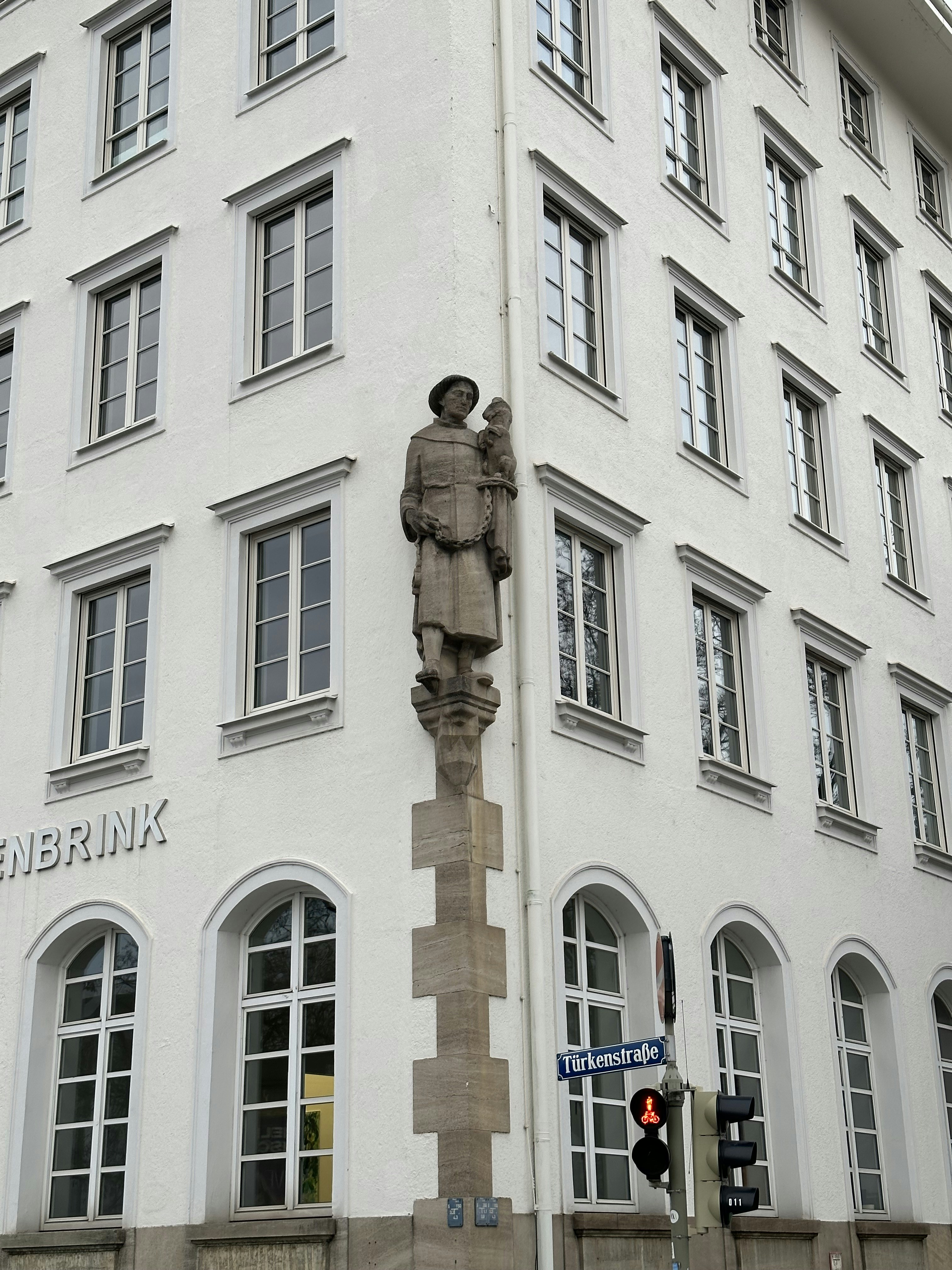 a tall white building with a statue of a man in front of it