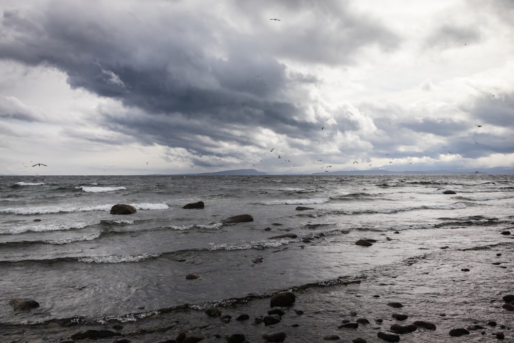 a large body of water under a cloudy sky