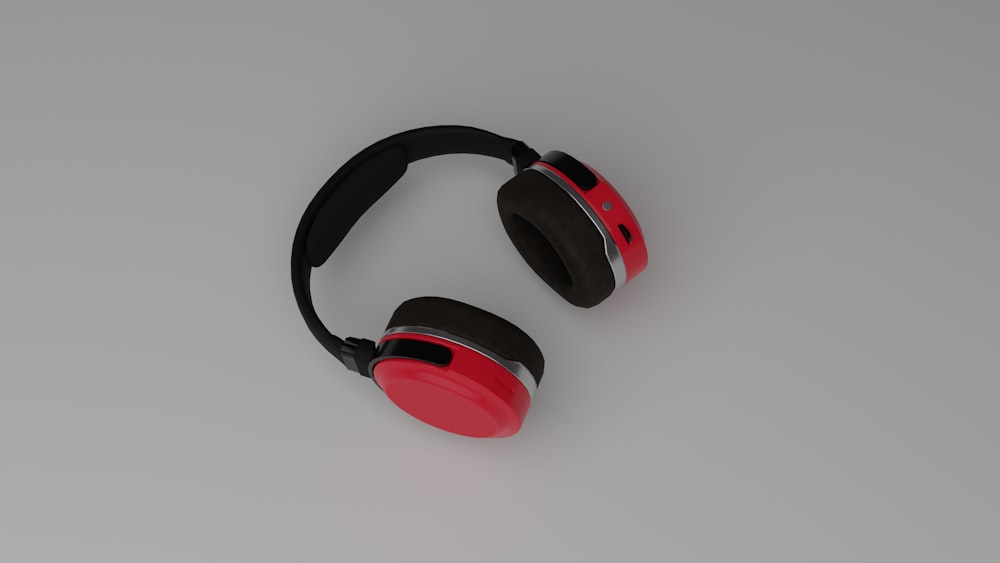 Ein Paar rote und schwarze Kopfhörer, die auf einem Tisch sitzen