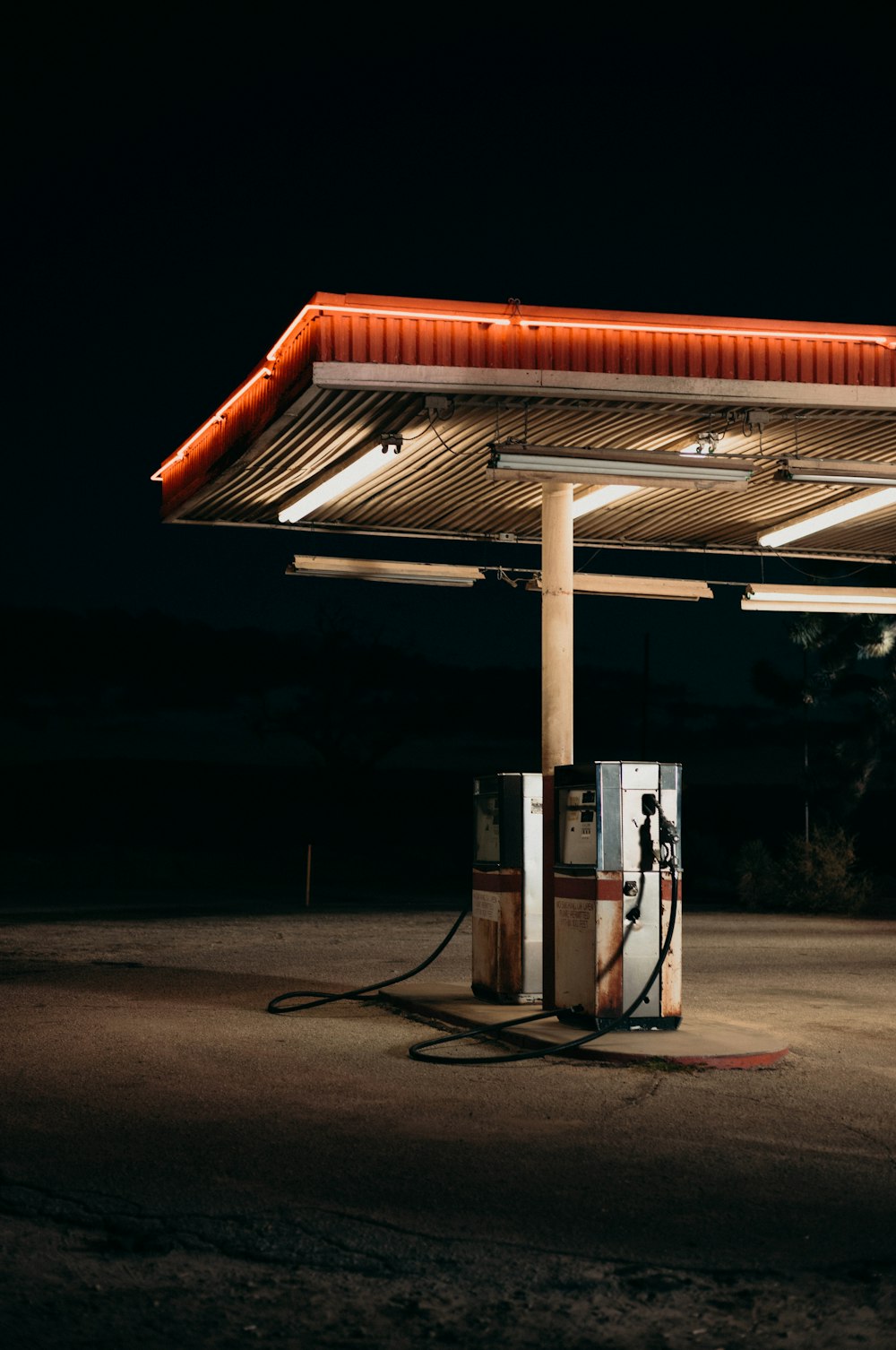 a gas station at night with a red roof
