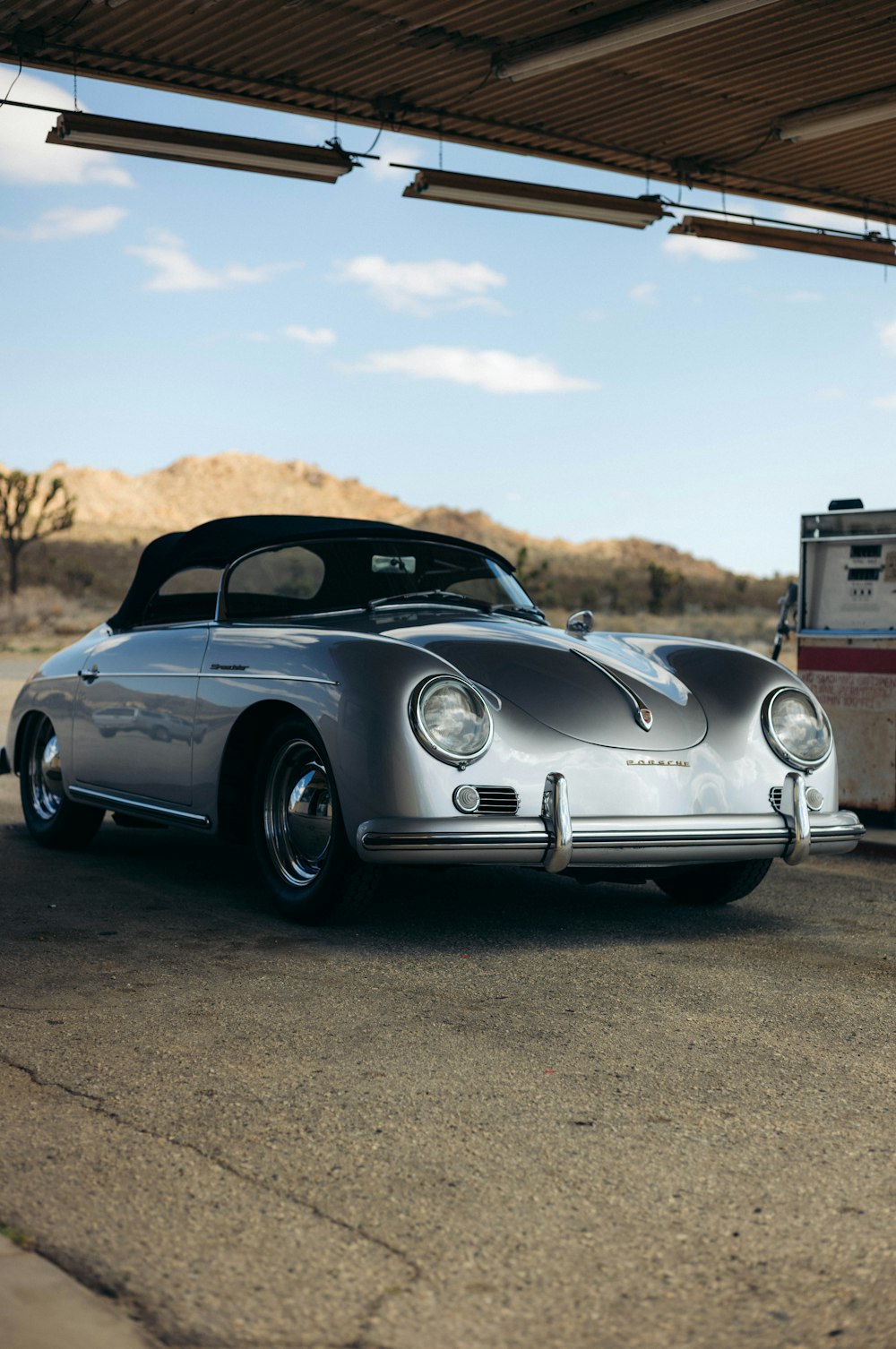 a silver car parked next to a gas pump