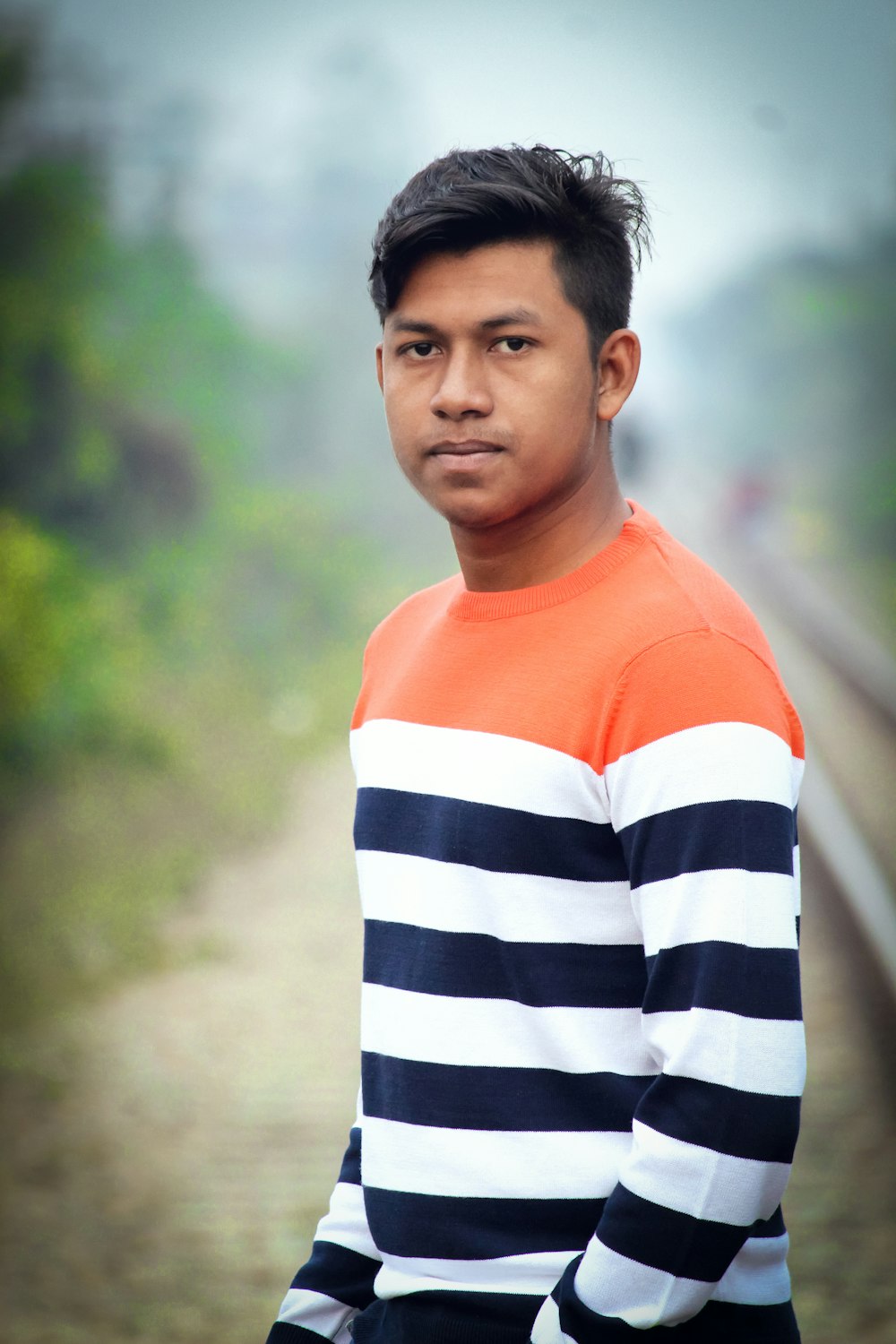 a man standing in front of a train track