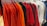 A collection of colorful t-shirts displayed on a rustic wooden table.